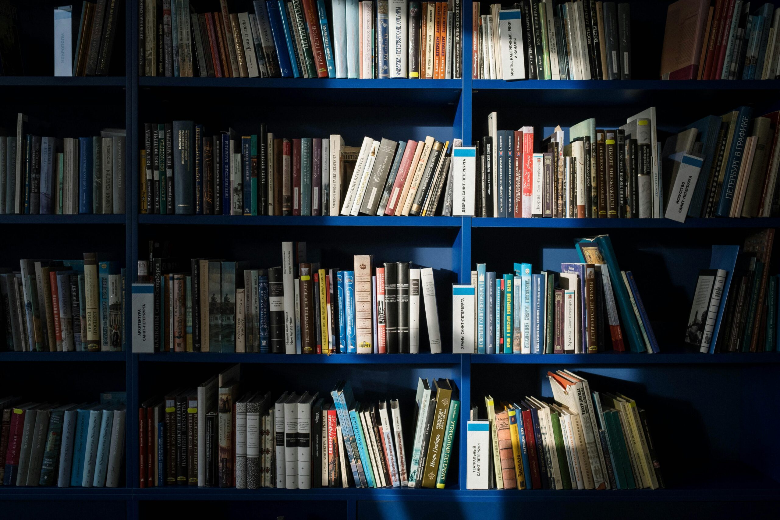 A well-stocked bookshelf filled with various books in a library setting, showcasing a spectrum of knowledge.